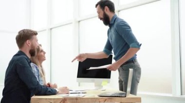 Manager and employees discussing a business document.