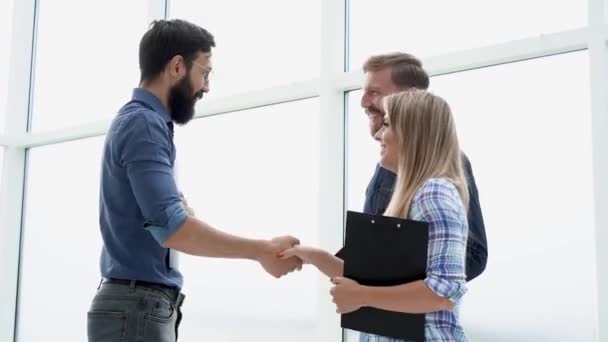 Employees greeting the Manager with a handshake in the office lobby. — Vídeos de Stock