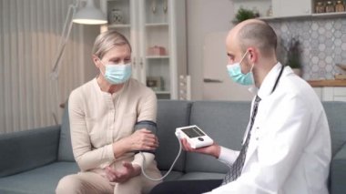 Doktor hastasına tonometre ekranını gösteriyor..