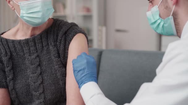 Arts die een vrouw vaccineert tegen een coronavirusinfectie. — Stockvideo