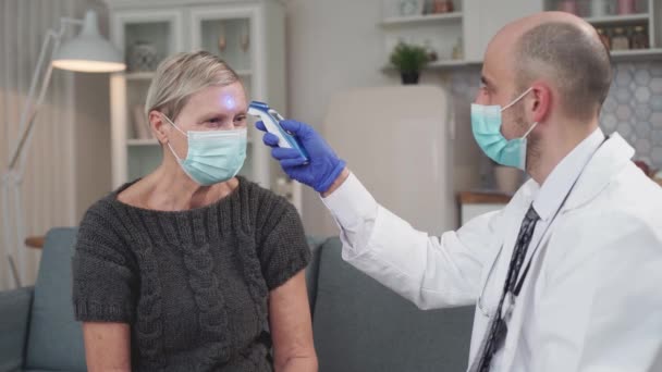 Doctor checks the temperature with an infrared thermometer. — Vídeo de Stock