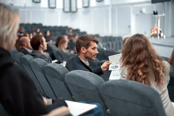 Collègues discutent des calendriers financiers assis dans la salle de conférence. — Photo