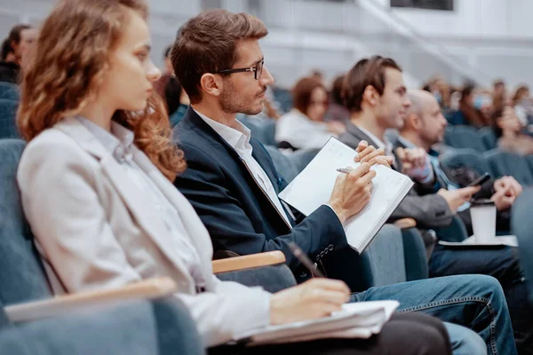 Participantes del seminario de negocios tomando notas en sus cuadernos. — Foto de Stock