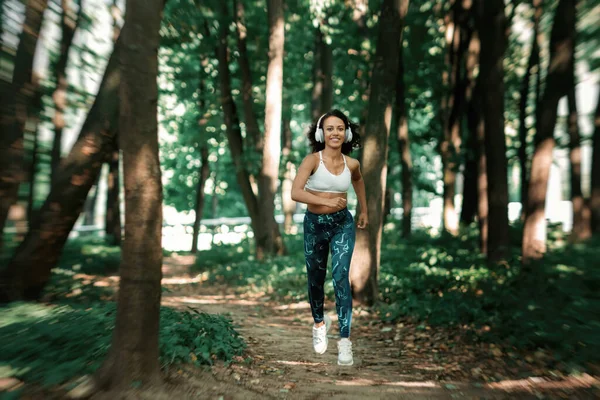 Jovem mulher em uma corrida na floresta. vista traseira. — Fotografia de Stock