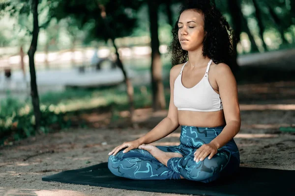 Jovem atlética meditando em um parque da cidade . — Fotografia de Stock