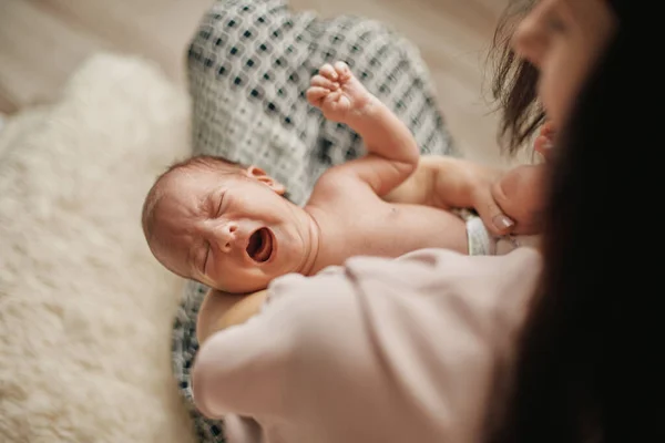 Weinendes hungriges Neugeborenes in den Armen seiner Mutter. — Stockfoto