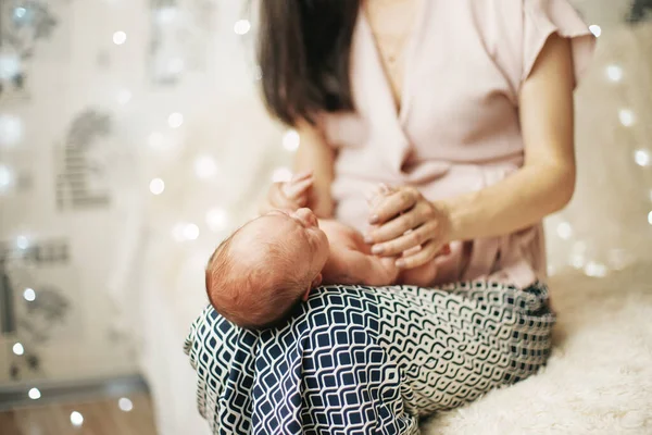 Feliz mamá jugando con un bebé recién nacido en sus brazos. — Foto de Stock