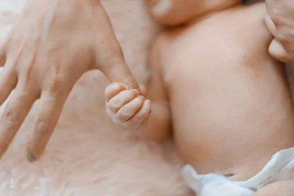 Il neonato tiene il dito delle sue mamme. primo piano. — Foto Stock