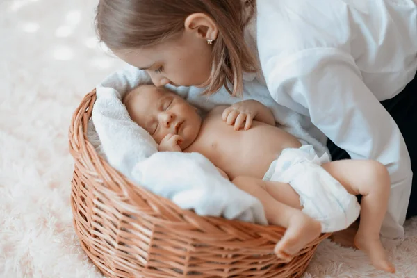 Klein meisje kijken naar haar pasgeboren broertje . — Stockfoto