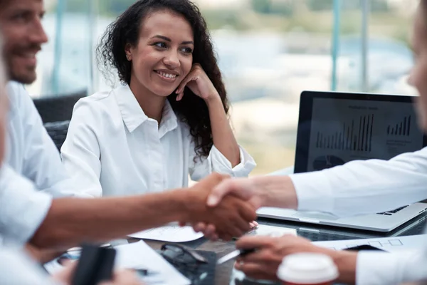 Feliz mujer de negocios mirando el apretón de manos de su socio de negocios — Foto de Stock