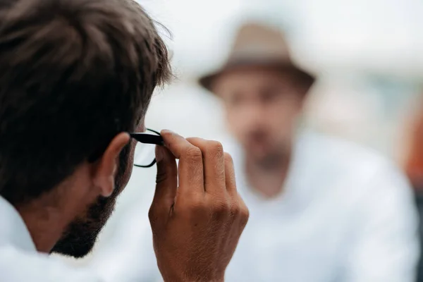 Joven hombre de negocios está mirando cuidadosamente a través de sus gafas. —  Fotos de Stock