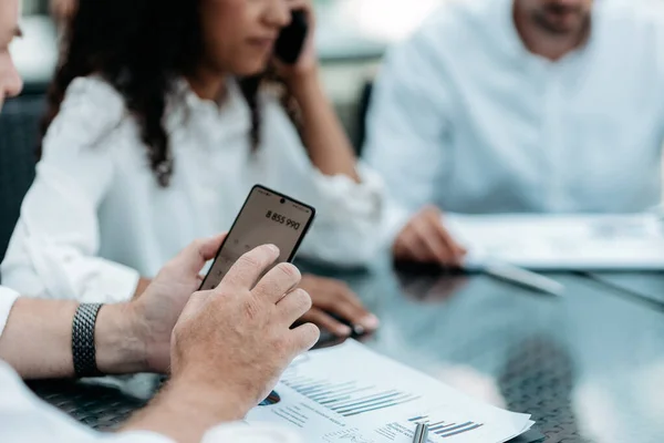 Empresário usando um smartphone enquanto trabalhava com docu financeiro — Fotografia de Stock