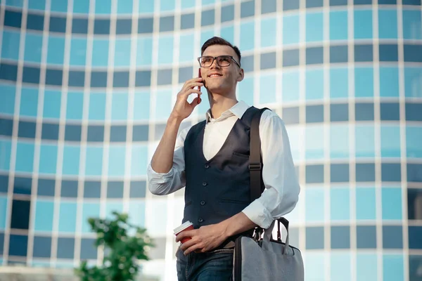 Akıllı telefonlu genç bir adam şehir caddesinde yürüyor. . — Stok fotoğraf