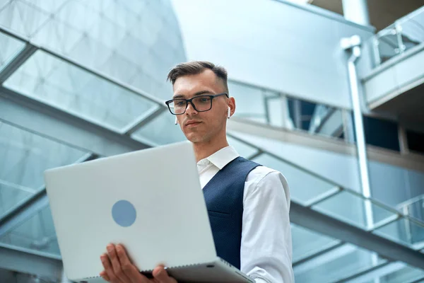 Young man with a laptop in a business center. — Stock Photo, Image