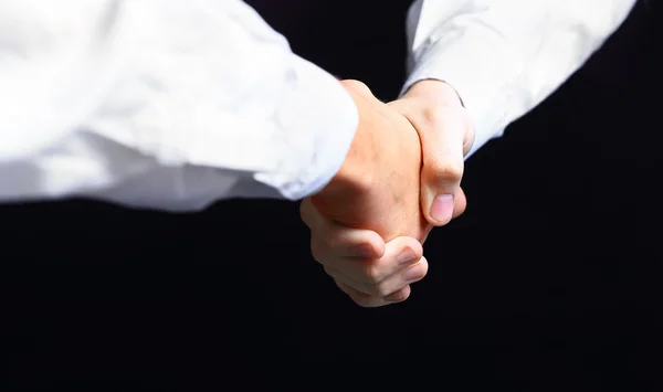 Kézfogás - kezében a fekete háttér — 스톡 사진