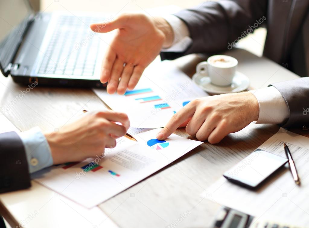 Image of male hand pointing at business document during discussion at meeting