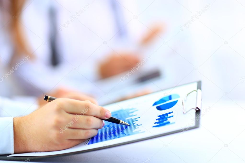 Modern people doing business, graphs and charts being demonstrated on the screen