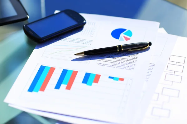 Gráficos financeiros na mesa com tablet e caneta — Fotografia de Stock