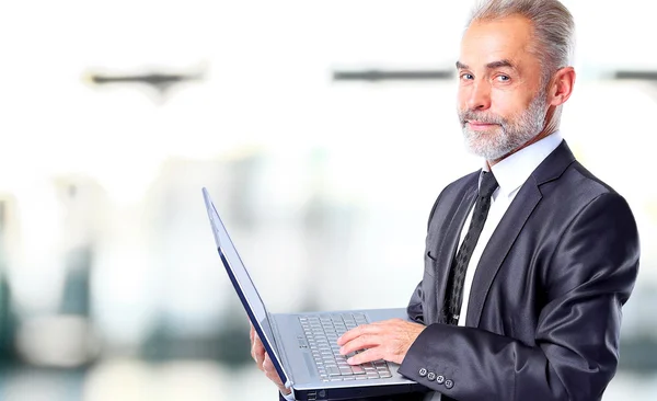 Zakenman met zijn laptopt in het kantoor — Stockfoto