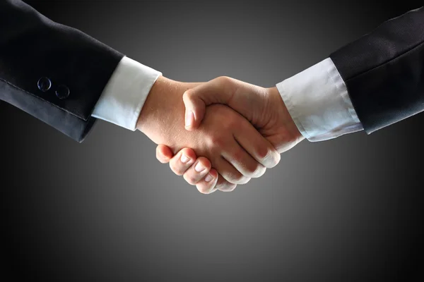 Handshake - Hand holding on black background — Stock Photo, Image