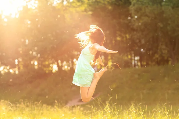 Šťastná dívka v paprscích zapadajícího slunce — Stock fotografie