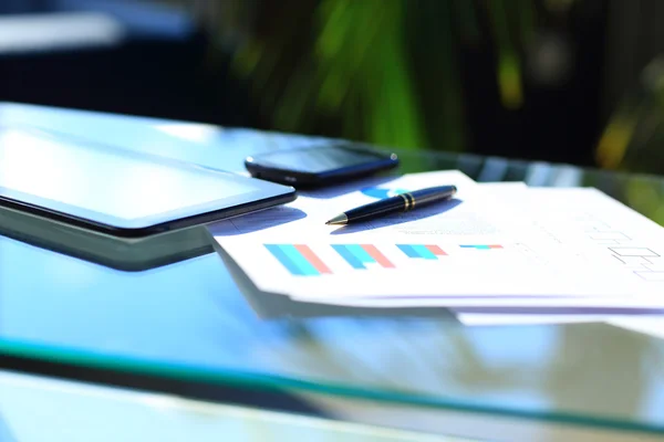 Tableaux financiers sur la table avec tablette et stylo — Photo