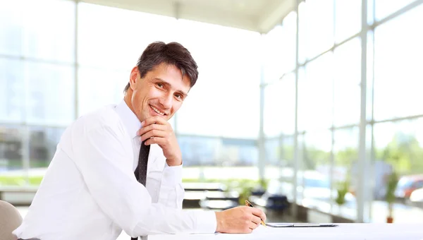 Snygg affärsman ler mot kontoret — Stockfoto