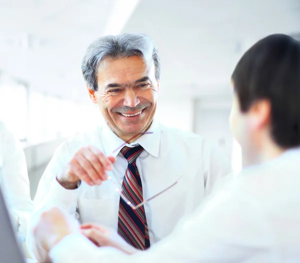 Ein dreiköpfiges Geschäftsteam, das im Büro sitzt und die Arbeit plant — Stockfoto