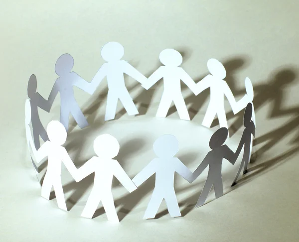 Team of paper doll people holding hands — Stock Photo, Image