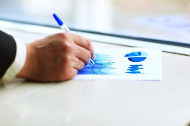 kişi masa başında oturan, satış kazancı hesaplamak ve numaraları ile dairesel diyagramı çizme