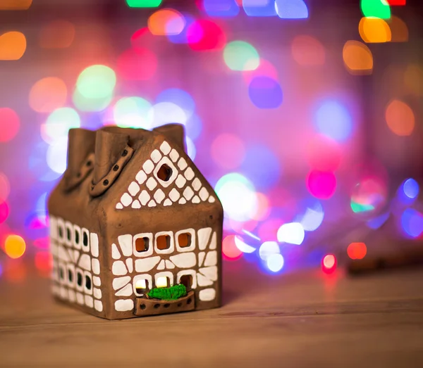 Fee Kerst huis taart met kaarslicht binnen, smalle diepte van het veld en achtergrondverlichting — Stockfoto