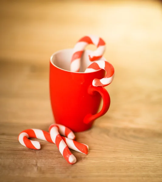 Caneca de chá ou café. Doces. Decorações de Natal. Bolas e Sinos Vermelhos. Fundo de madeira . — Fotografia de Stock