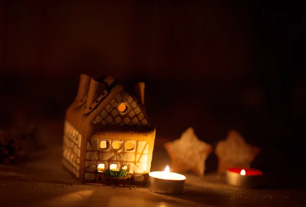 Fee Kerst huis taart met kaarslicht binnen en mooie achtergrondverlichting — Stockfoto