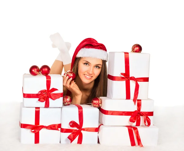 Chica con regalos de Navidad acostado en la alfombra, sonriendo y mirando a la cámara —  Fotos de Stock