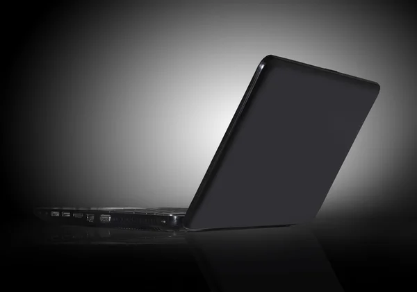 Black laptop on black background with reflection — Stock Photo, Image