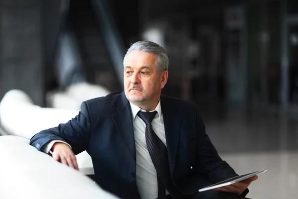 Empresario en la oficina con la tableta se sienta y trabaja — Foto de Stock