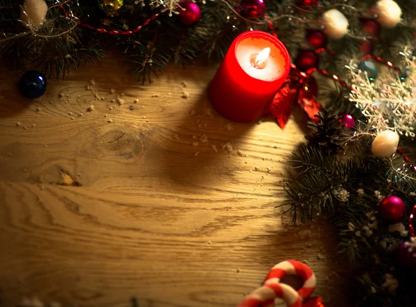 Ramos de abeto verde no chão de madeira com decorações de Natal e velas — Fotografia de Stock