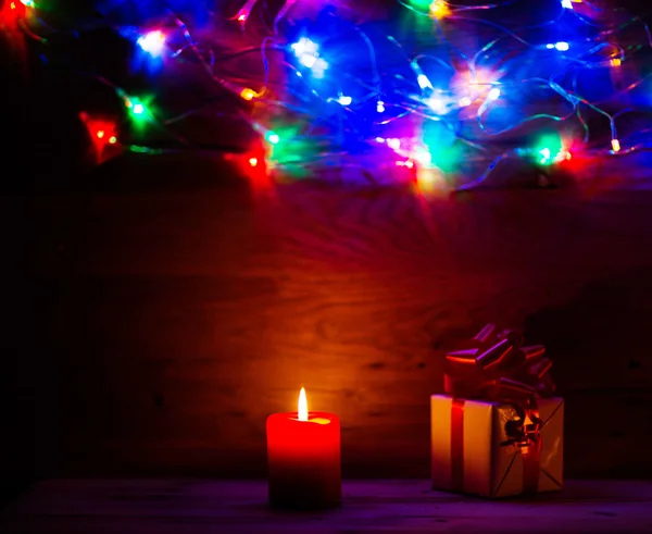 Bellissimo sfondo in legno per etichette con luci di Natale regalo e con candele — Foto Stock