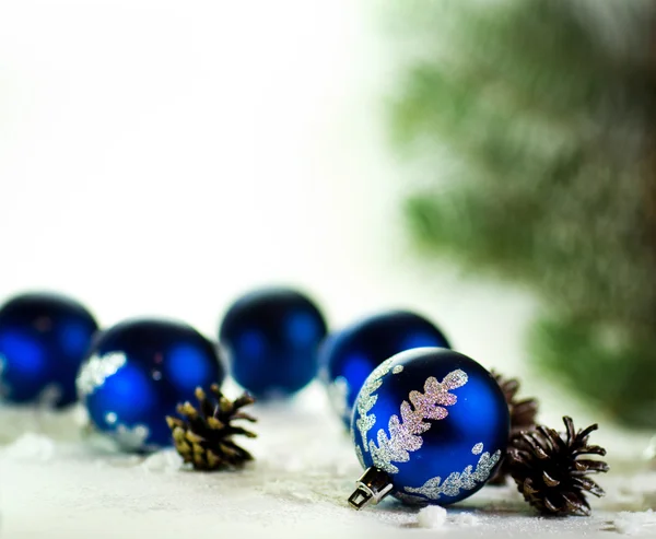 Blue Christmas balls op witte achtergrond met fir kegels — Stockfoto