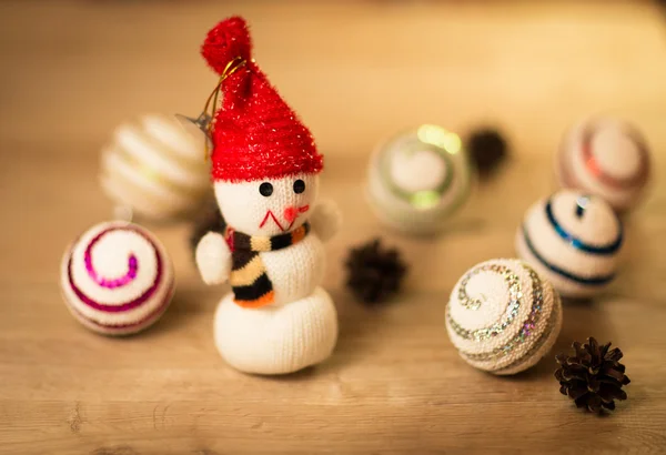 Mooie sneeuwpop met kerstballen en mooie verlichting op houten achtergrond — Stockfoto