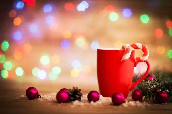 Рождественская кружка с украшениями и сладостями на деревянном фоне — стоковое фото