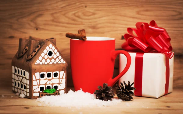 Mug Of Tea Or Coffee. Gift with red ribbon and . Sweets And Spices. Christmas Decorations. Wooden Background. — Stock Photo, Image