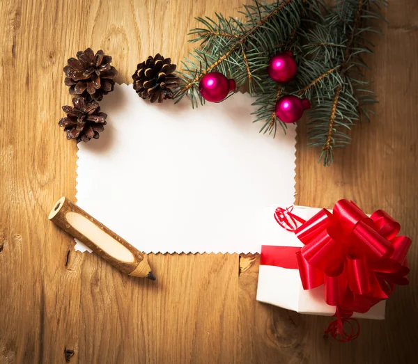 Tarjeta de Navidad: en blanco, regalo rural vintage y rama de árbol de Navidad sobre fondo de madera con regalo — Foto de Stock