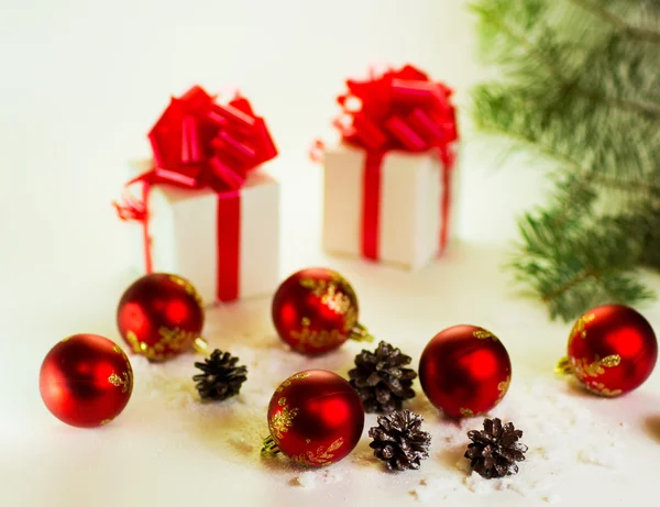 Подарки на белом фоне с рождественскими шарами — стоковое фото