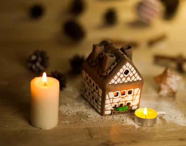 Víla vánoční dům dort se svíčkou světlo uvnitř a pěkné pozadí světla — Stock fotografie