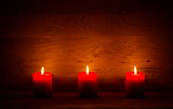 Candles on the old wooden background with shading around the edges — Stock Photo, Image