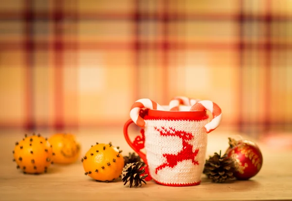 Insulated wool cloth mug with embroidered deer on the wooden table mug with tangerines and a candy