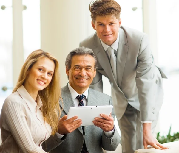 Serious business team with tablet pc computers, documents having discussion in office — Stock Photo, Image