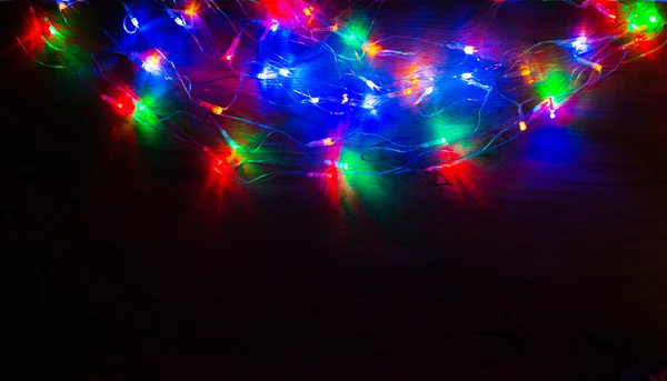 Luces de Navidad sobre fondo de madera con sombreado alrededor de los bordes —  Fotos de Stock