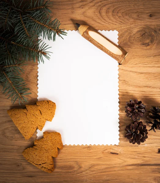 Hoja de papel en blanco en el suelo de madera con un lápiz y decoraciones de Navidad —  Fotos de Stock